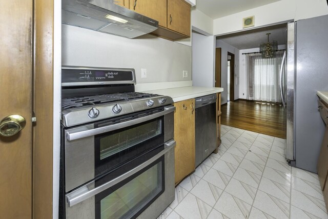 1620 Whittier Rd, Ypsilanti, MI 48197 - kitchen featuring stainless steel appliances, extractor fan, brown cabinetry, light countertops, and light tile patterned flooring