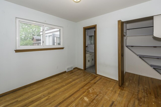1620 Whittier Rd, Ypsilanti, MI 48197 - unfurnished bedroom with wood finished floors, baseboards, ensuite bath, and a closet
