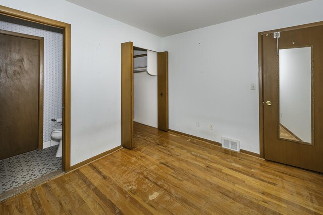 1620 Whittier Rd, Ypsilanti, MI 48197 - unfurnished bedroom with wood finished floors, baseboards, and connected bathroom