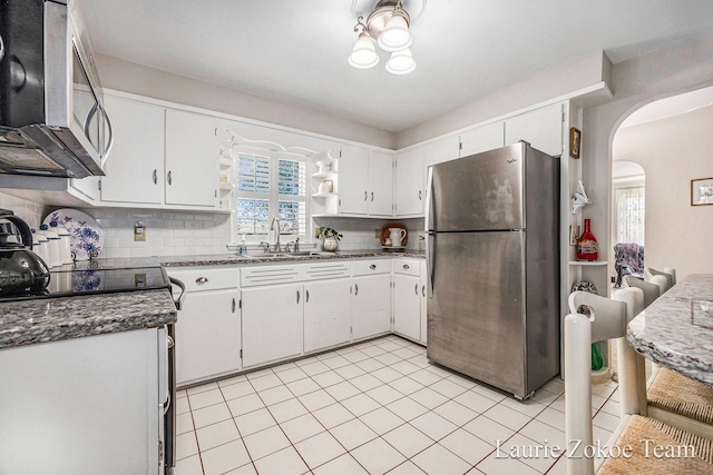 347 Dewitt Ln, Spring Lake, MI 49456 - kitchen featuring stainless steel appliances, a sink, arched walkways, backsplash, and white cabinets
