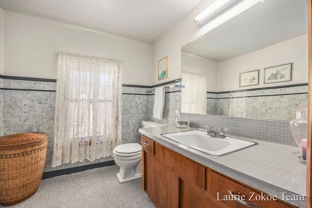 347 Dewitt Ln, Spring Lake, MI 49456 - bathroom with tile walls, a wainscoted wall, vanity, and toilet