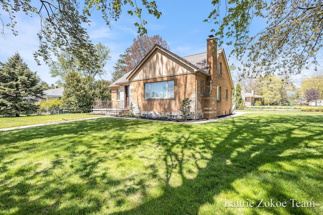 347 Dewitt Ln, Spring Lake, MI 49456 - tudor home with a chimney, brick siding, and a front yard