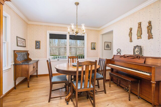 dining room with wallpapered walls, a chandelier, ornamental molding, and light wood-style flooring