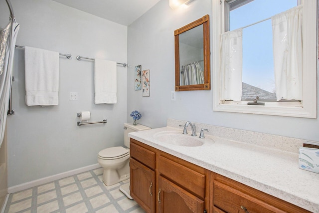 bathroom featuring tile patterned floors, baseboards, vanity, and toilet
