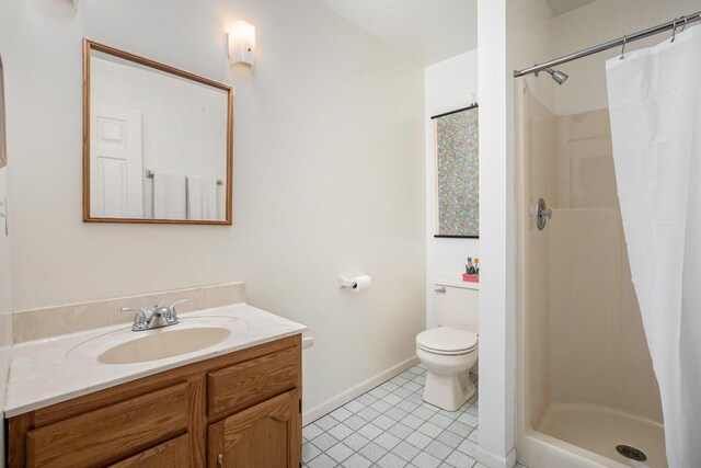 bathroom featuring tile patterned flooring, vanity, toilet, baseboards, and a stall shower