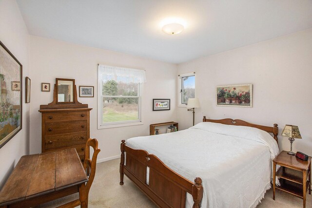 bedroom featuring baseboards and light carpet