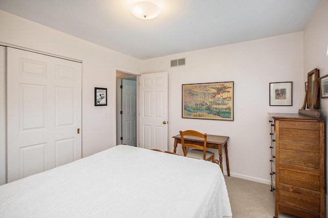 bedroom with a closet, baseboards, light colored carpet, and visible vents