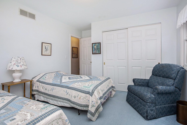 carpeted bedroom featuring a closet and visible vents