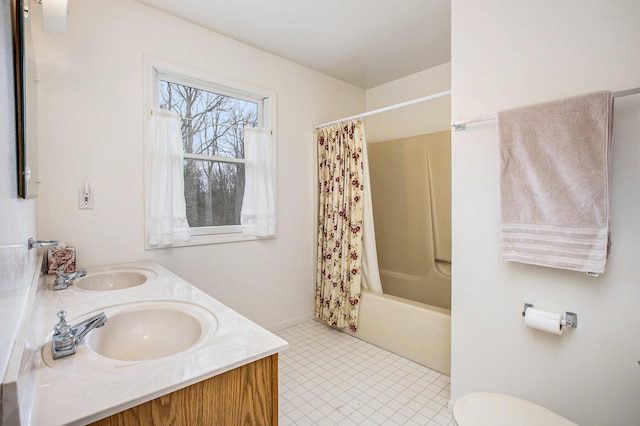 bathroom featuring double vanity, a sink, shower / bath combo, and toilet