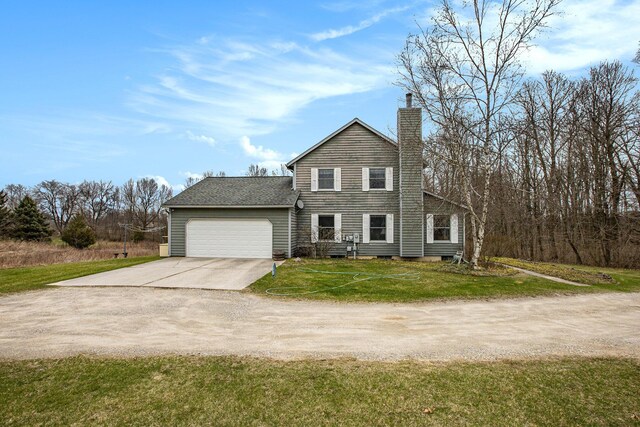 traditional-style house featuring an attached garage, a front yard, a chimney, and concrete driveway