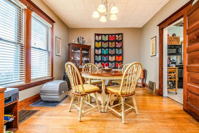 815 Wolcott Ave, Saint Joseph, MI 49085 - dining area with light wood finished floors, a chandelier, healthy amount of natural light, and baseboards