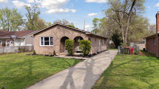 view of front facade with fence, concrete driveway, a front yard, and brick siding