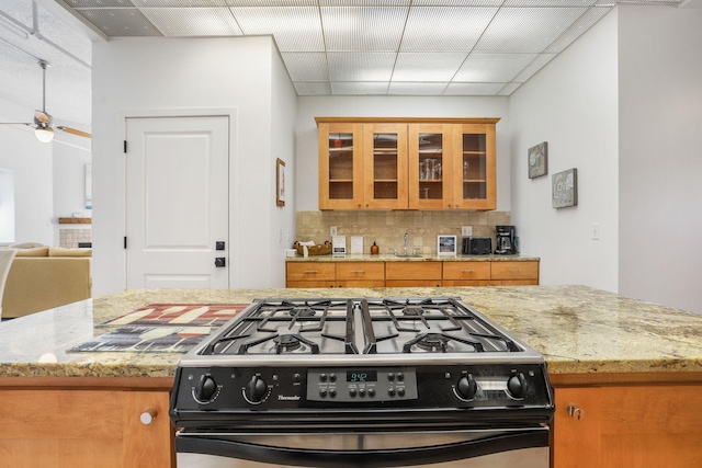 532 Dyckman Ave Unit B1A, South Haven, MI 49090 - kitchen featuring black gas range, brown cabinets, tasteful backsplash, light stone countertops, and a paneled ceiling