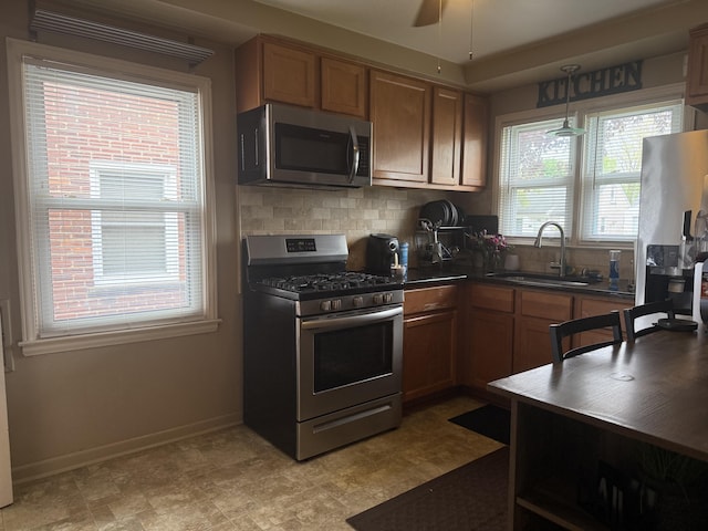 9705 Wormer Ave, Redford, MI 48239 - kitchen featuring dark countertops, appliances with stainless steel finishes, a sink, baseboards, and backsplash