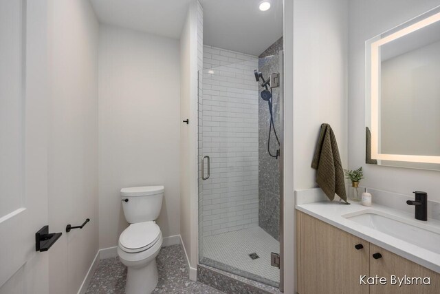 144 Oakes St SW Unit 1905, Grand Rapids, MI 49503 - bathroom featuring vanity, toilet, baseboards, tile patterned floors, and a shower stall