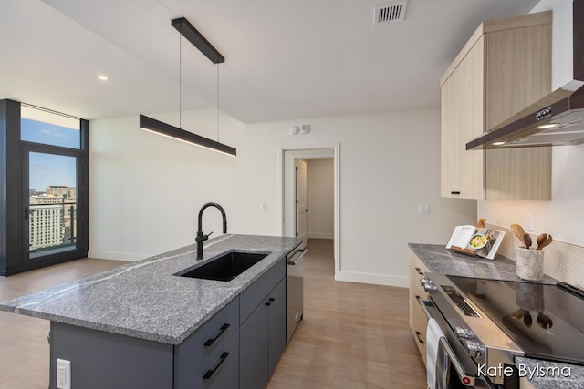 144 Oakes St SW Unit 1905, Grand Rapids, MI 49503 - kitchen featuring visible vents, appliances with stainless steel finishes, light stone countertops, a sink, and wall chimney exhaust hood