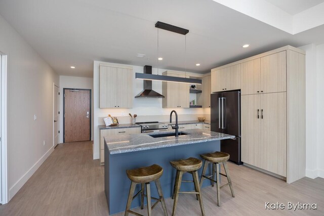 144 Oakes St SW Unit 1905, Grand Rapids, MI 49503 - kitchen featuring a kitchen bar, modern cabinets, high quality fridge, light wood finished floors, and wall chimney exhaust hood