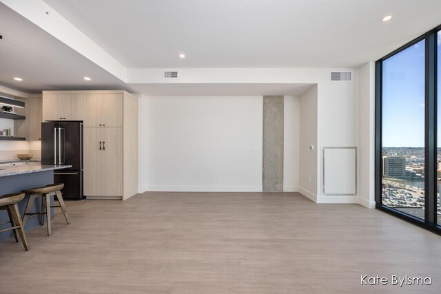 144 Oakes St SW Unit 1905, Grand Rapids, MI 49503 - living room with visible vents, floor to ceiling windows, and light wood finished floors