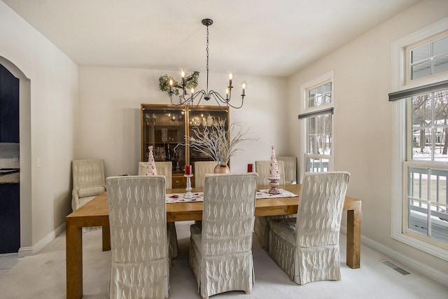 6847 Northstar Ave, Kalamazoo, MI 49009 - carpeted dining space with arched walkways, a chandelier, and baseboards