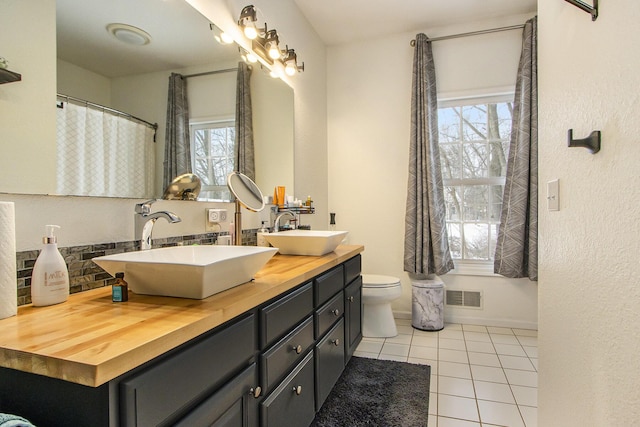 6847 Northstar Ave, Kalamazoo, MI 49009 - full bathroom with tile patterned floors, plenty of natural light, toilet, and backsplash