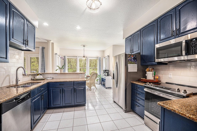 6847 Northstar Ave, Kalamazoo, MI 49009 - kitchen featuring appliances with stainless steel finishes, a sink, blue cabinets, a peninsula, and tasteful backsplash