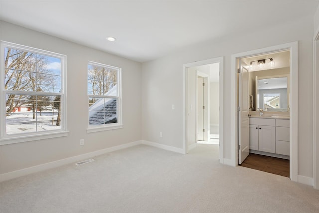 6602 E E Ave, Richland, MI 49083 - unfurnished bedroom featuring carpet floors, ensuite bath, baseboards, and a sink