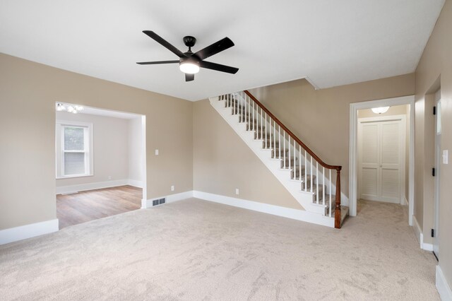 123 N 2nd St, Cassopolis, MI 49031 - unfurnished living room featuring carpet, a ceiling fan, visible vents, baseboards, and stairway