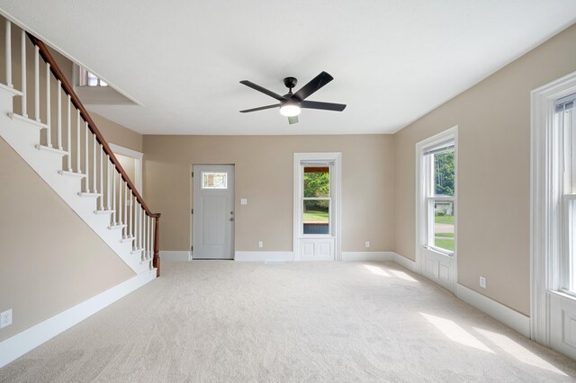 123 N 2nd St, Cassopolis, MI 49031 - unfurnished living room featuring light carpet, baseboards, ceiling fan, and stairs