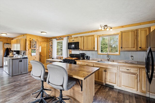 1366 Grow Rd NW, Stanton, MI 48888 - kitchen featuring black appliances, wooden counters, a sink, dark wood-style floors, and a breakfast bar