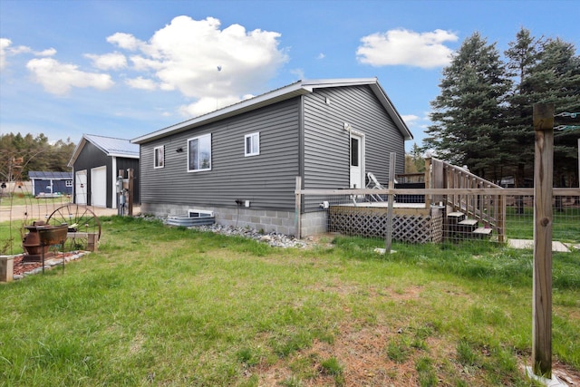 1366 Grow Rd NW, Stanton, MI 48888 - back of property featuring a detached garage, a deck, a lawn, and an outdoor structure