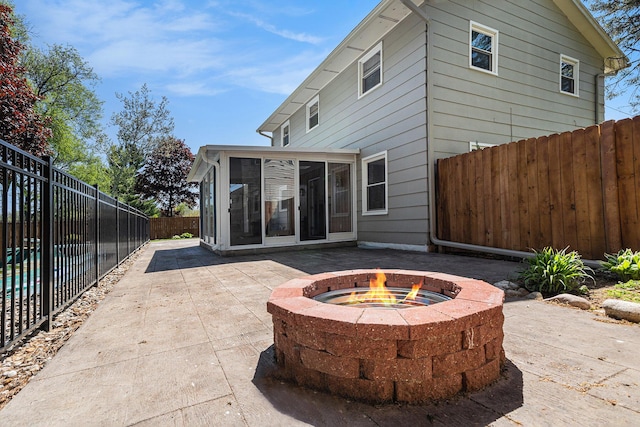 105 N Dr E, Marshall, MI 49068 - back of house featuring a sunroom, a fire pit, a patio area, and a fenced backyard
