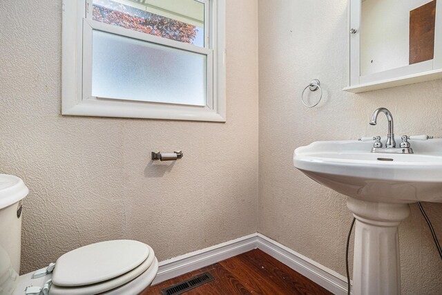 105 N Dr E, Marshall, MI 49068 - half bath featuring toilet, wood finished floors, baseboards, and a sink