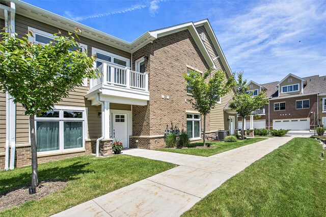 603 Woodland, Dexter, MI 48130 - townhome / multi-family property featuring a balcony, central air condition unit, and brick siding