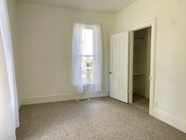 501 E Paw Paw St, Paw Paw, MI 49079 - unfurnished bedroom featuring a spacious closet, carpet floors, a closet, and baseboards