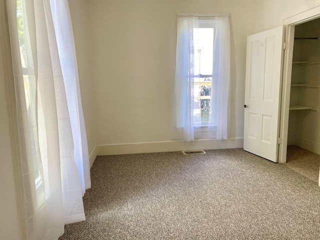 501 E Paw Paw St, Paw Paw, MI 49079 - unfurnished bedroom featuring carpet floors, a closet, a spacious closet, and baseboards