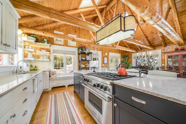 kitchen with high end range, a sink, wood ceiling, open shelves, and light wood finished floors