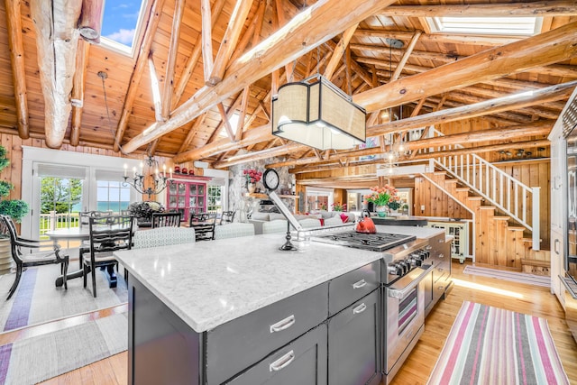 kitchen with high end stove, gray cabinets, a skylight, wood ceiling, and a chandelier