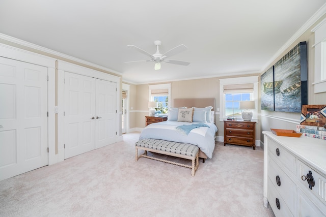 bedroom with ornamental molding, light colored carpet, ceiling fan, and a closet