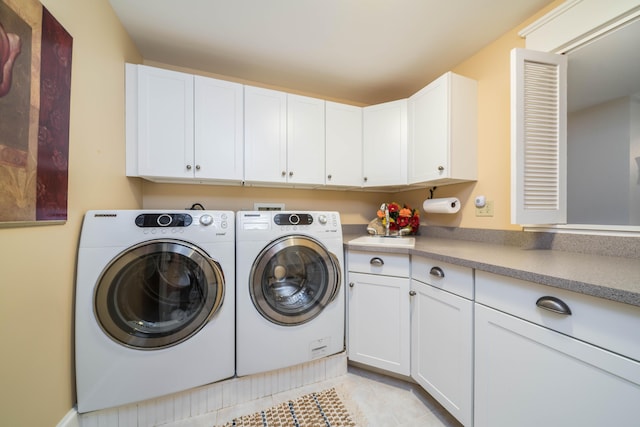 clothes washing area featuring cabinet space, washing machine and dryer, and light tile patterned floors