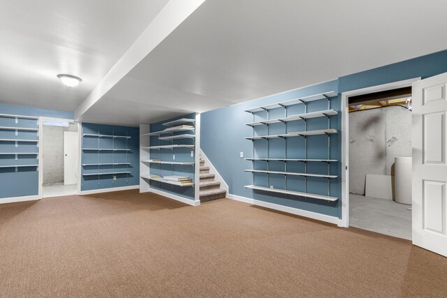 finished below grade area with carpet, baseboards, stairway, and built in shelves