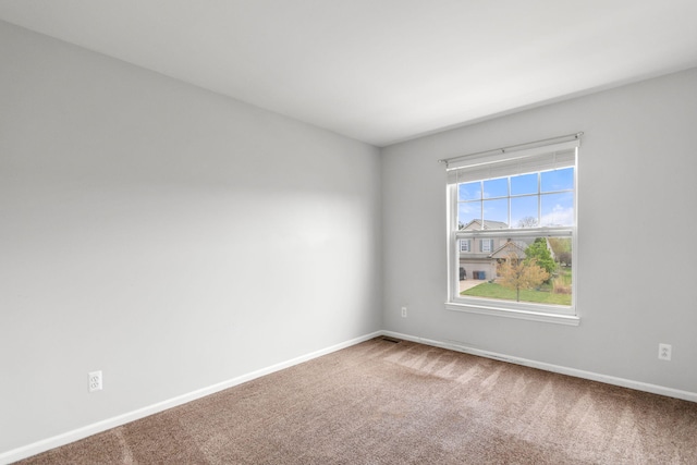 carpeted spare room with baseboards