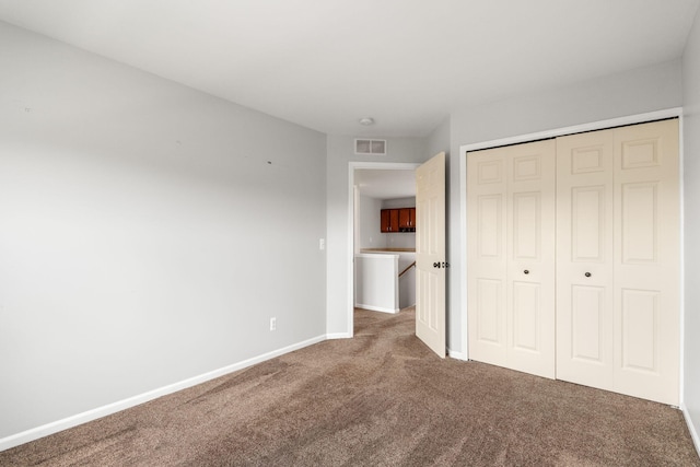 unfurnished bedroom featuring carpet, baseboards, and a closet
