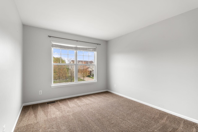empty room featuring carpet and baseboards