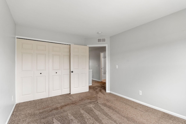 unfurnished bedroom featuring carpet flooring, baseboards, and a closet