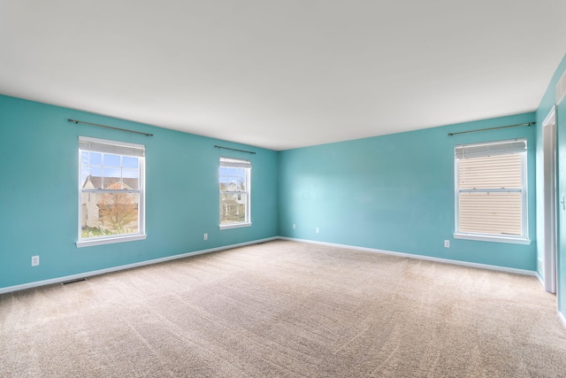 empty room featuring carpet and baseboards