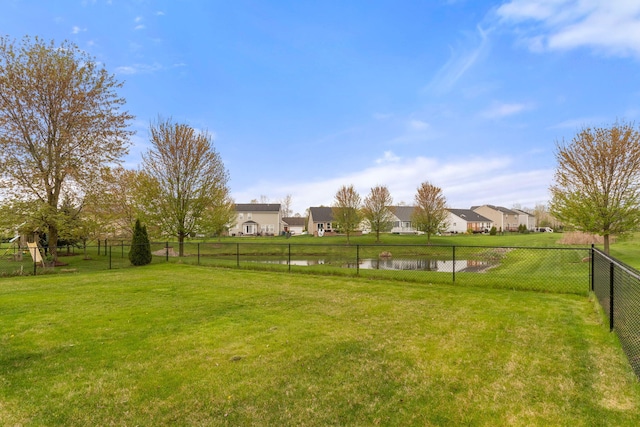 view of yard with a residential view and a water view