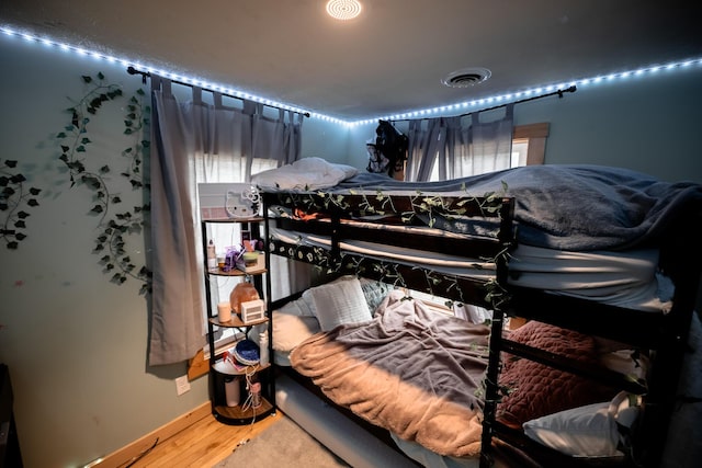 bedroom featuring visible vents, wood finished floors, and baseboards