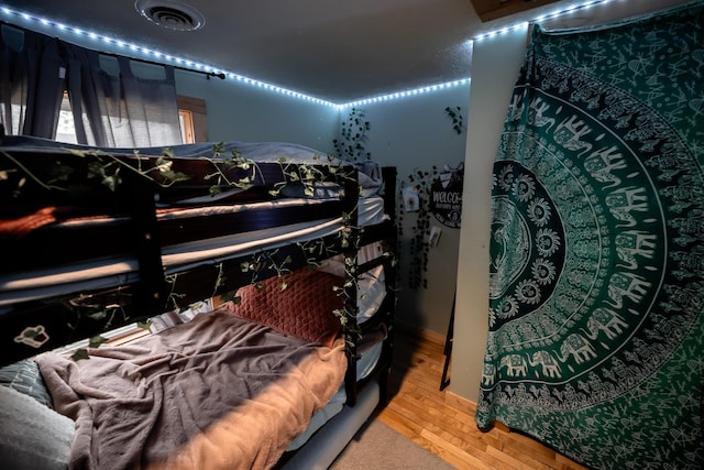 bedroom with visible vents and wood finished floors