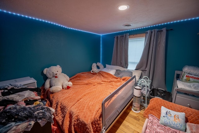 bedroom with visible vents and wood finished floors