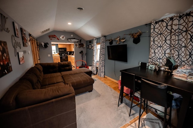 living room with vaulted ceiling, light wood finished floors, baseboards, and visible vents